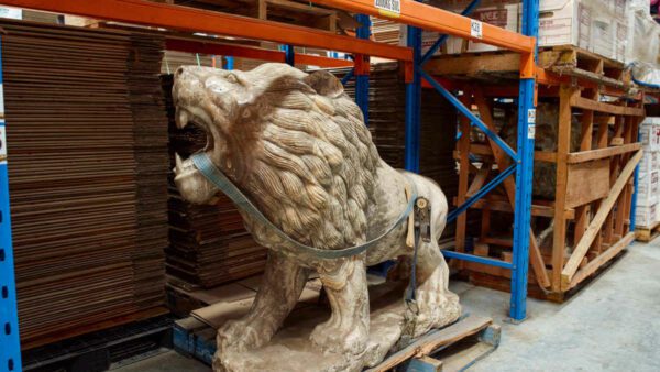 A large lion sculpture is stored securely in a professional Kent storage warehouse facility.