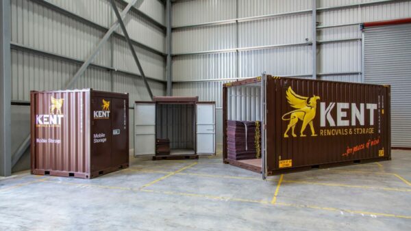 Three Kent Storage storage solution containers sit in a Kent Storage warehouse facility.